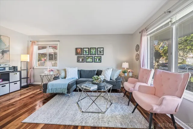 a living room with furniture wooden floor and a large window