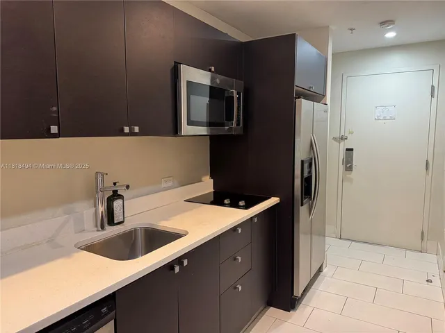 a view of swimming pool with lawn chairs and palm trees