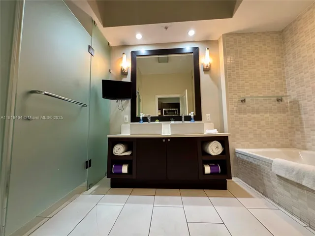 a bathroom with a bathtub a mirror and a shower