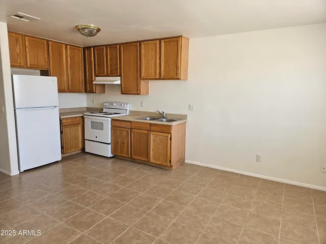 a kitchen with a stove a sink and a refrigerator