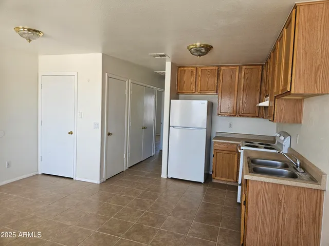 a kitchen with a refrigerator sink and cabinets