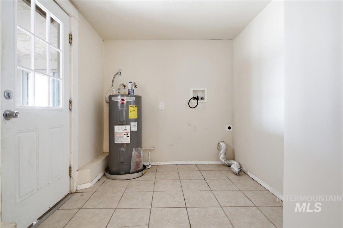 3929-3927 Homestead Road Homedale, ID 83628 - Photo 42 of 45 Utility room with tiled flooring, a water heater, and appliance hookups
