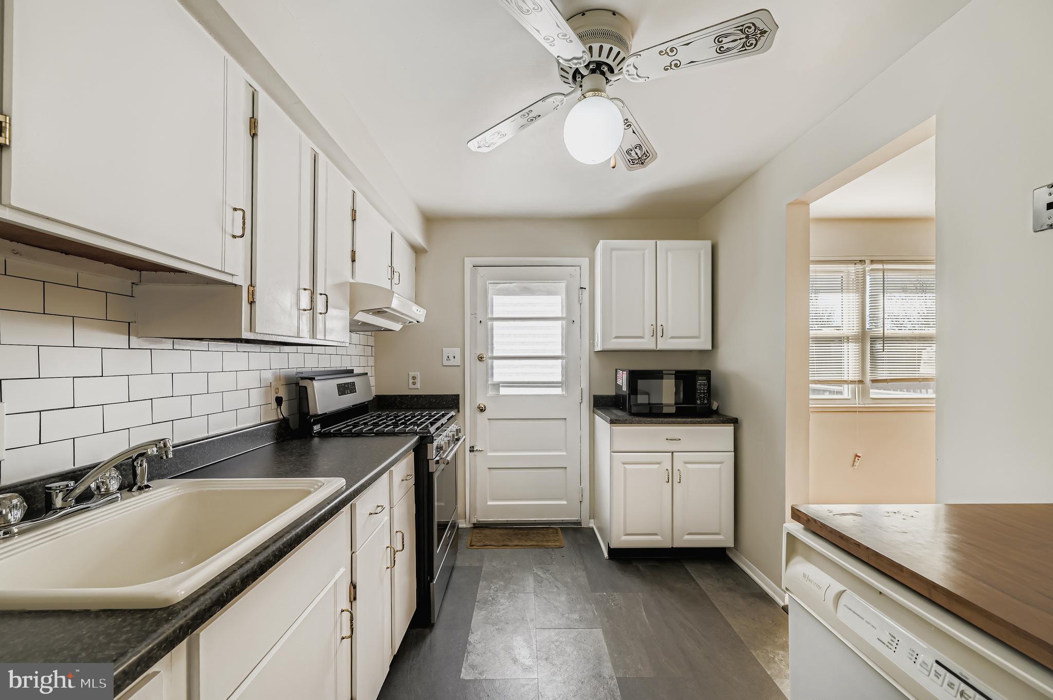 658 Kingston Road Baltimore, MD 21220 - Photo 12 of 28 a kitchen with granite countertop a sink stove and cabinets