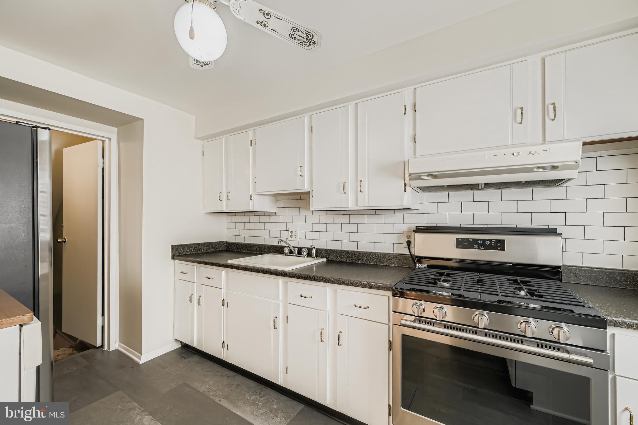 658 Kingston Road Baltimore, MD 21220 - Photo 13 of 28 a kitchen with granite countertop white cabinets and stainless steel appliances