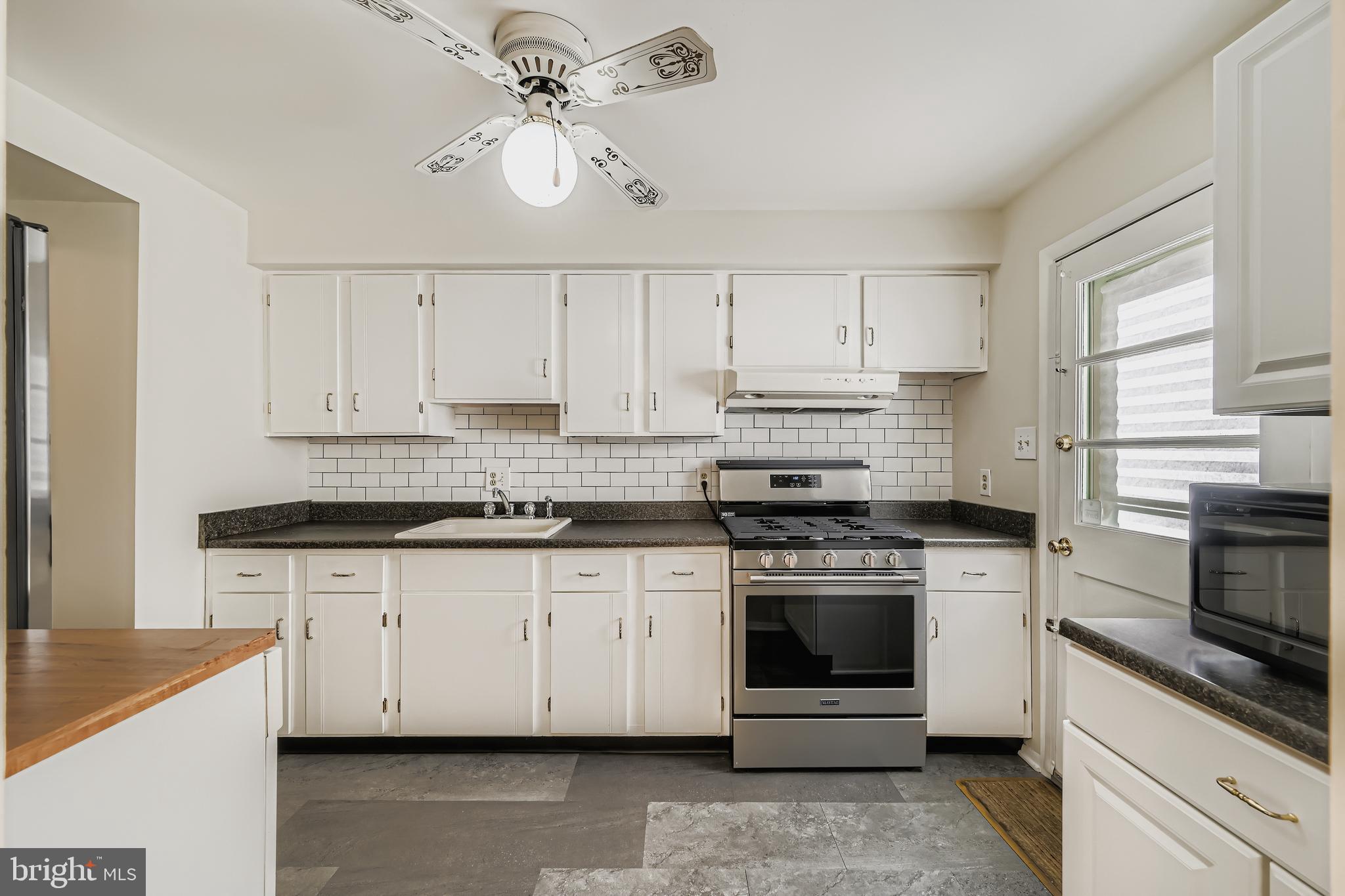 658 Kingston Road Baltimore, MD 21220 - Photo 14 of 28 a kitchen with granite countertop a stove sink and cabinets