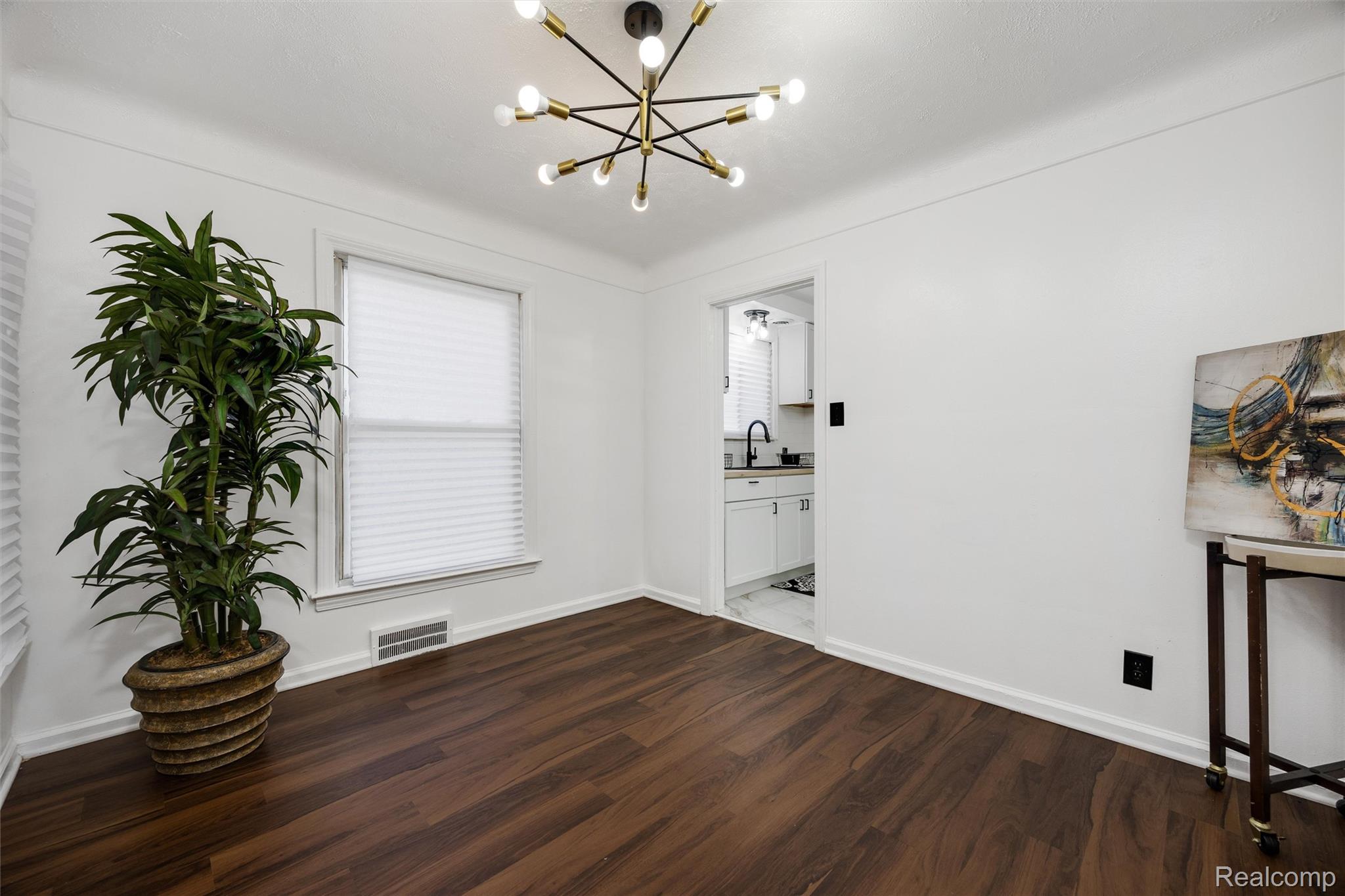 11566 Nottingham Road Detroit, MI 48224 - Photo 7 of 23 Wood-finish flooring, contemporary ceiling light fixture, white interior walls, and a window with blinds