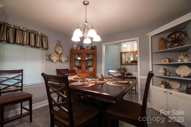 a view of a dining room with furniture a rug and wooden floor