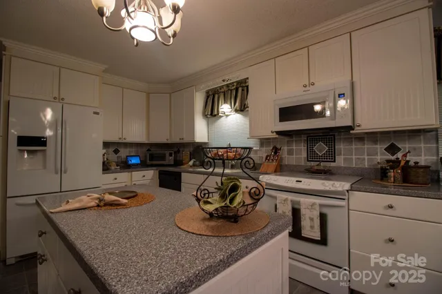 a kitchen with kitchen island granite countertop a sink stainless steel appliances and cabinets