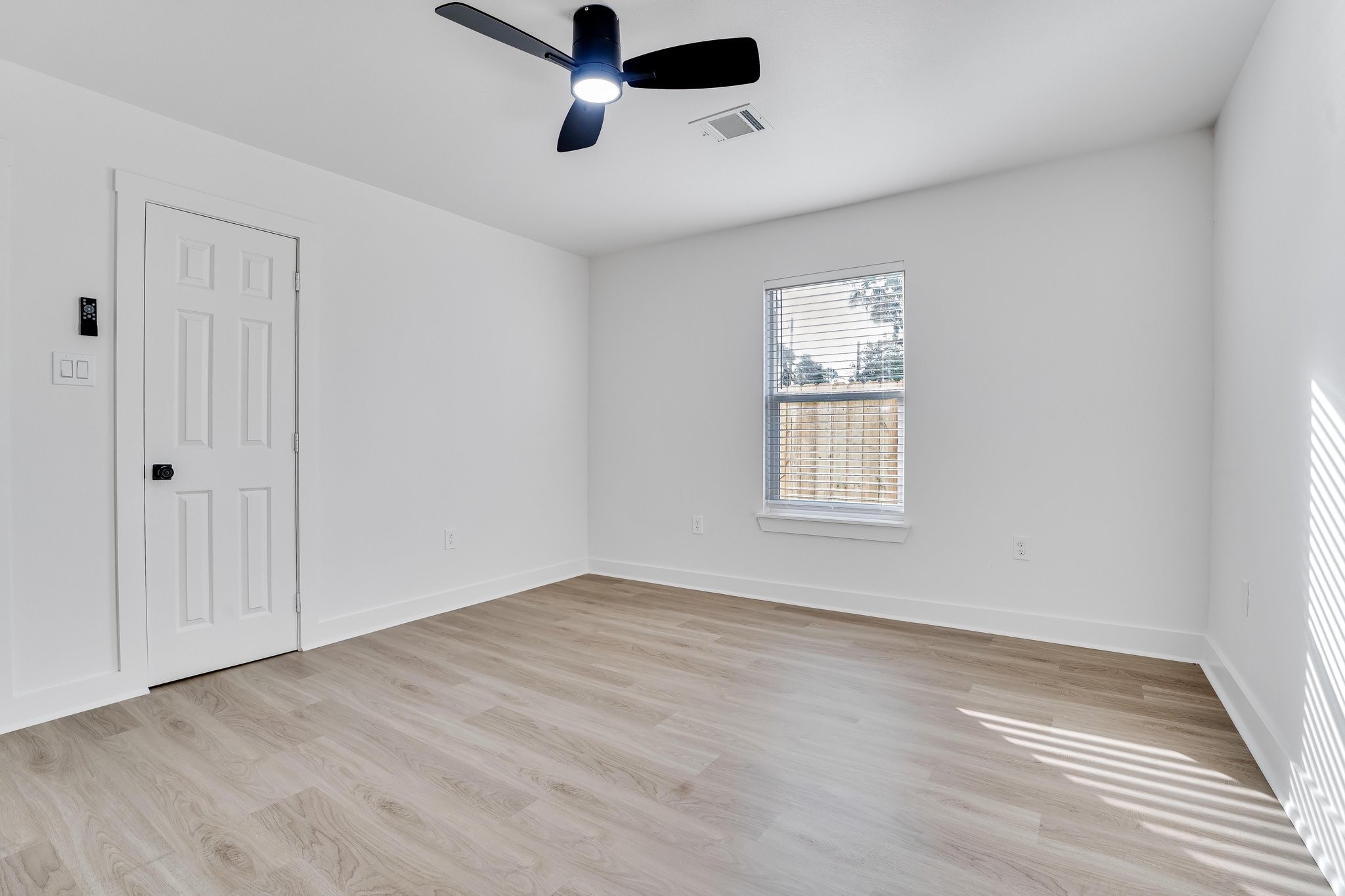 6123 Tuskegee Street Houston, TX 77091 - Photo 11 of 13 a view of an empty room with a window and a ceiling fan