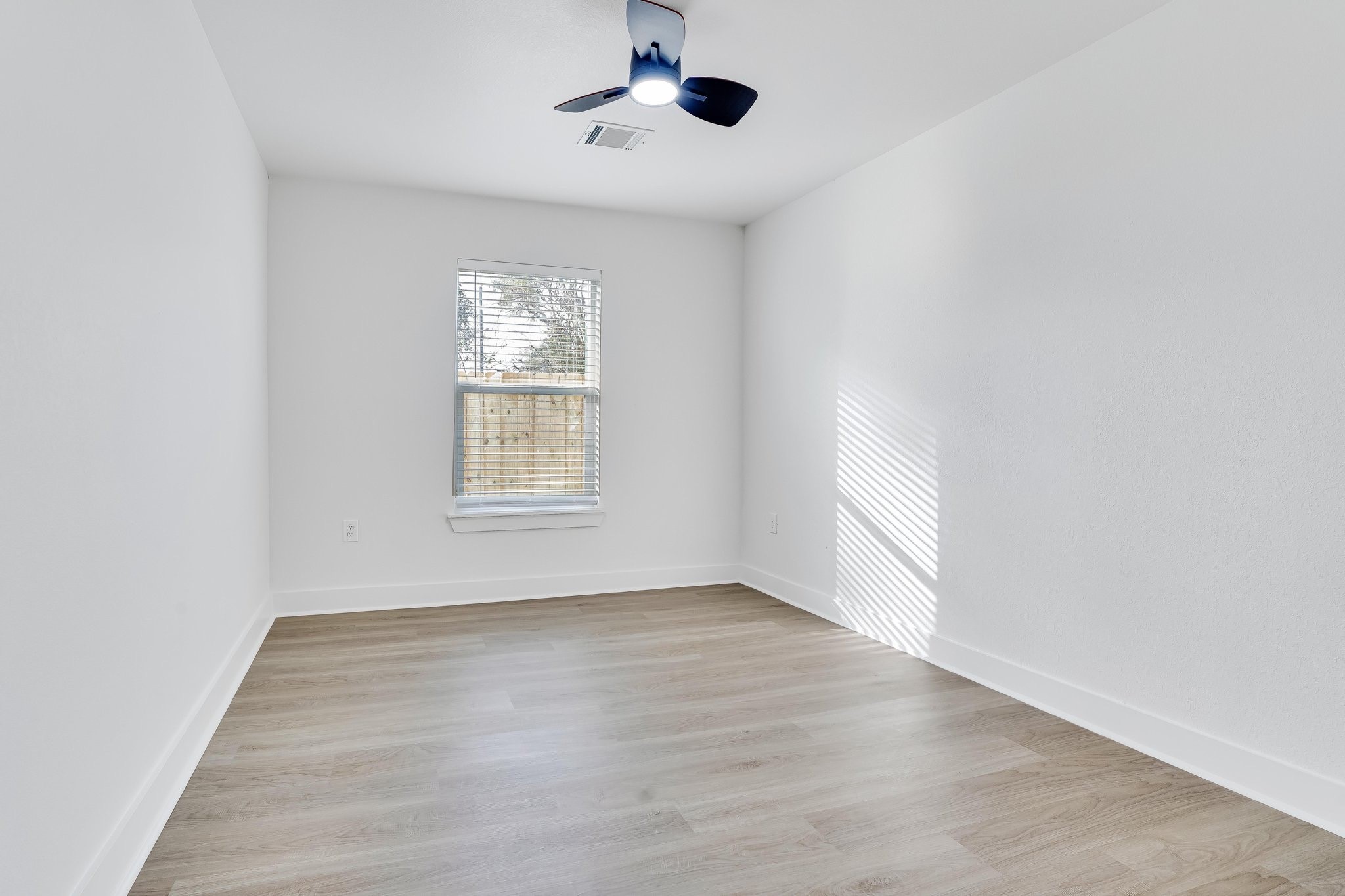 6123 Tuskegee Street Houston, TX 77091 - Photo 13 of 13 an empty room with wooden floor cabinet and windows