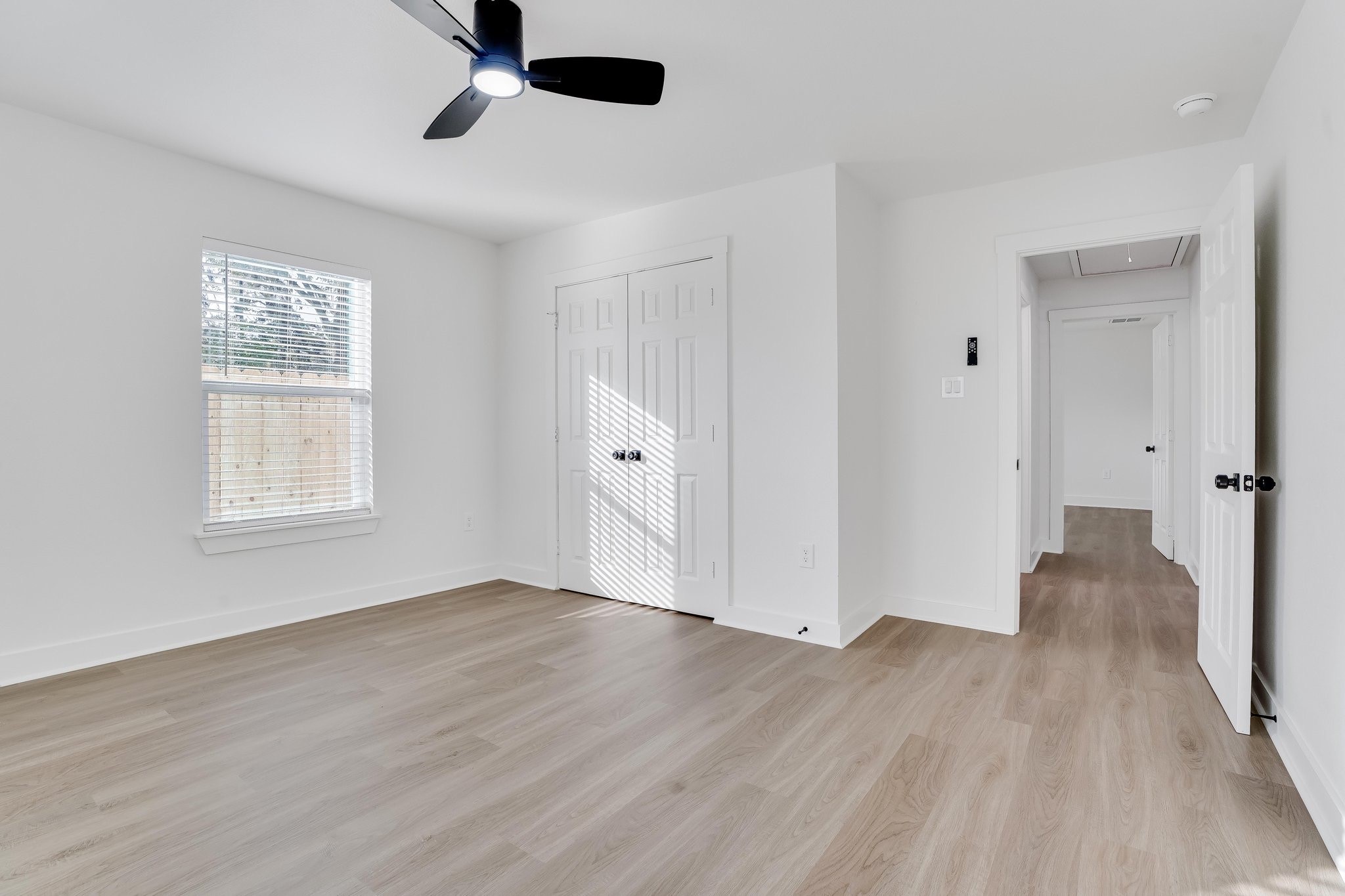 6123 Tuskegee Street Houston, TX 77091 - Photo 9 of 13 an empty room with wooden floor cabinet and windows