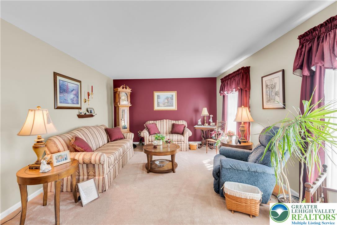 4059 Old Sentry Road Allentown, PA 18104 - Photo 5 of 39 A traditional living area featuring a plush carpeted floor, offering a warm and inviting atmosphere for relaxation.