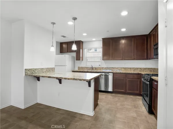 a large kitchen with granite countertop a sink and a stove top oven