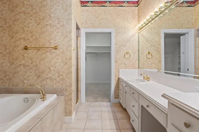 a spacious bathroom with a tub sink shower and mirror