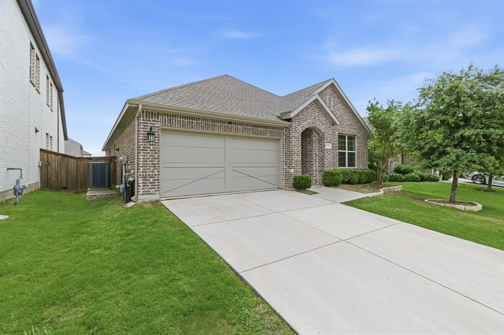 3721 Prickly Pear Road Little Elm, TX 75068 - Photo 2 of 21 Brick exterior home featuring an attached two-car garage with a light-colored door, a concrete driveway, and a front walkway