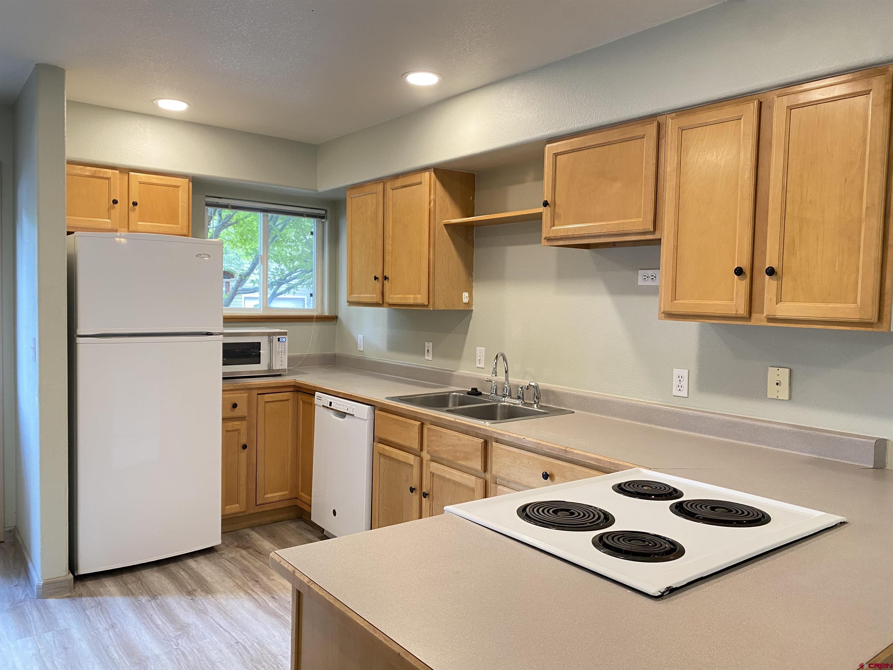 33 Sunridge Lane Durango, CO 81301 - Photo 6 of 37 a kitchen with a refrigerator a sink and cabinets