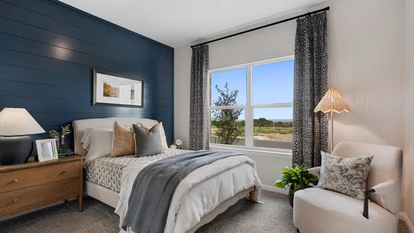 a bedroom with a large bed and a potted plant
