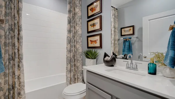 a bathroom with a granite countertop sink a toilet a mirror and shower