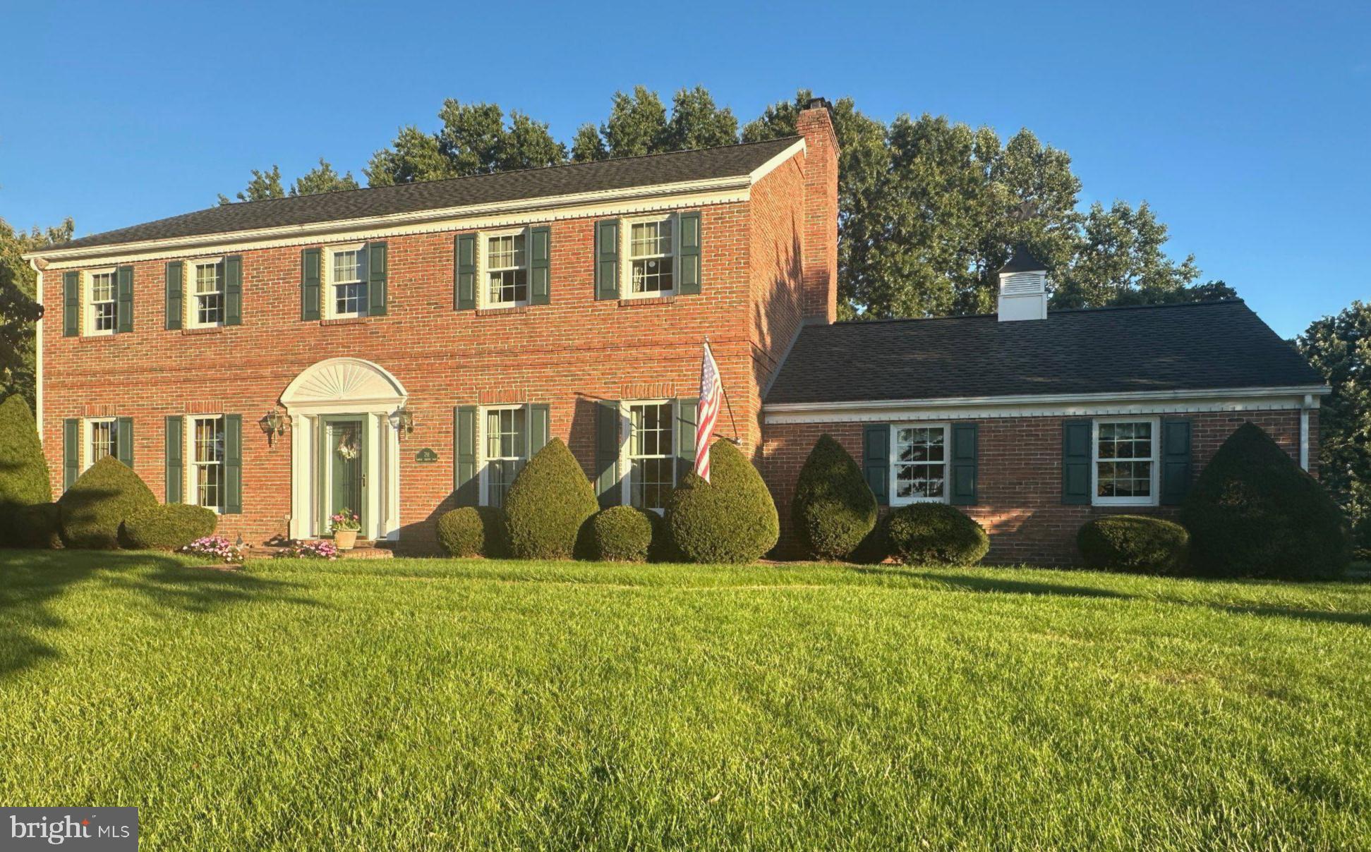 Classic brick home with lush greenery.