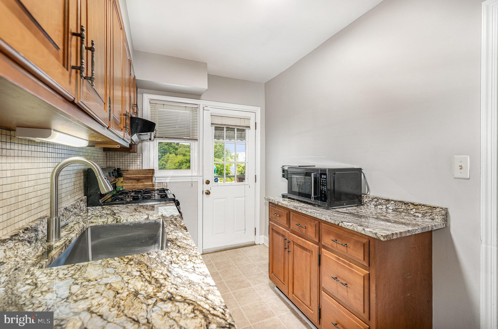 200 Riverthorn Road Middle River, MD 21220 - Photo 13 of 46 a kitchen with stainless steel appliances kitchen island granite countertop a stove a sink and a microwave