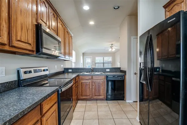 a kitchen with stainless steel appliances granite countertop a stove a sink and a refrigerator