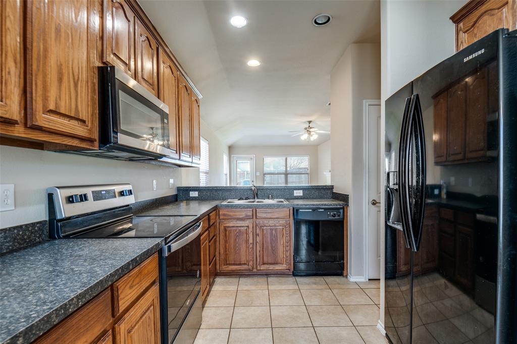 2044 Jack County Drive Forney, TX 75126 - Photo 3 of 9 a kitchen with stainless steel appliances granite countertop a stove a sink and a refrigerator