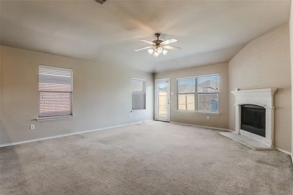 a view of empty room with windows and fireplace