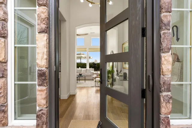 a kitchen with stainless steel appliances a stove a refrigerator a sink a dining table and chairs with wooden floor