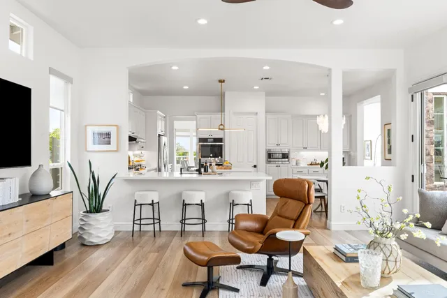 a view of a patio with couches table and chairs under an umbrella