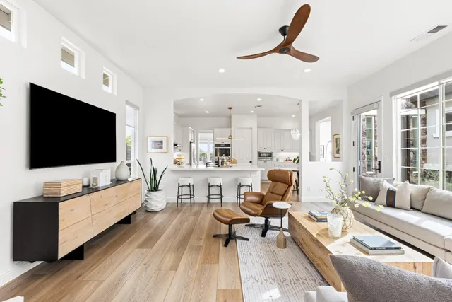 a view of a patio with couches table and chairs under an umbrella
