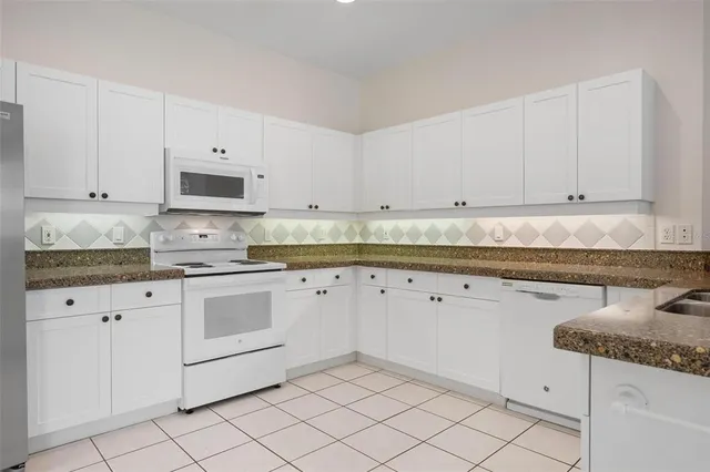 a view of an empty room with chandelier fan