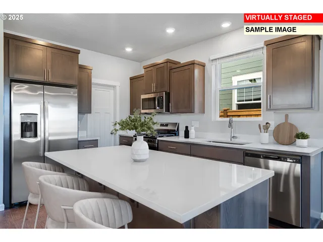 a kitchen with kitchen island a sink stainless steel appliances and cabinets