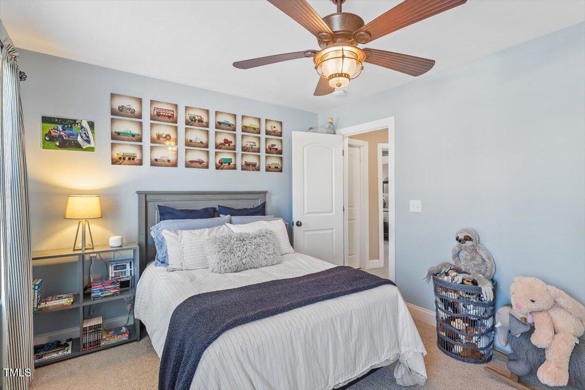 3504 Griffice Mill Road Raleigh, NC 27610 - Photo 21 of 39 a bedroom with a bed and a chandelier