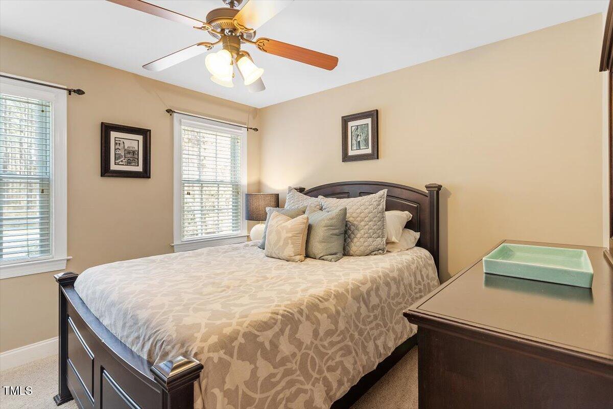 3504 Griffice Mill Road Raleigh, NC 27610 - Photo 22 of 39 a bedroom with a bed and a chandelier