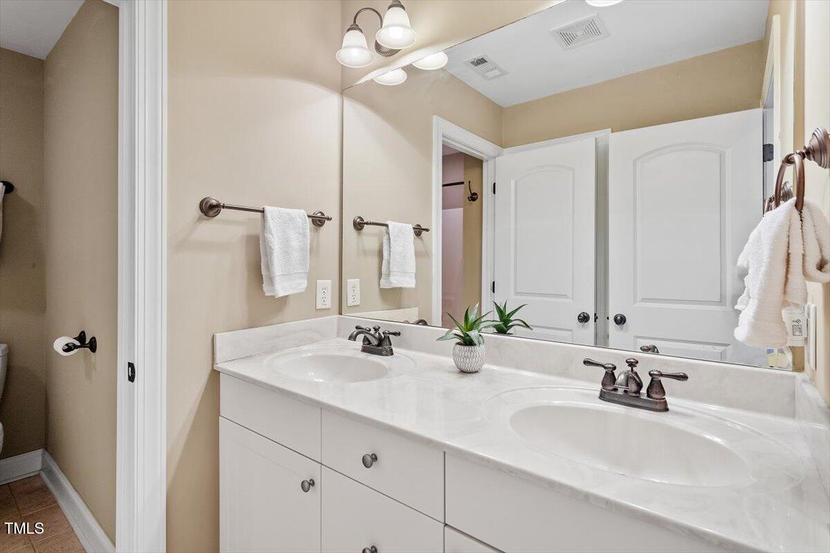 3504 Griffice Mill Road Raleigh, NC 27610 - Photo 23 of 39 a bathroom with double vanity sinks a vanity and a mirror