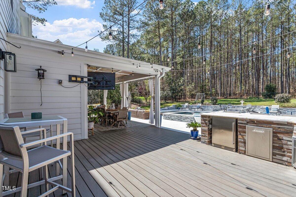 3504 Griffice Mill Road Raleigh, NC 27610 - Photo 31 of 39 a view of a patio with table and chairs and wooden floor
