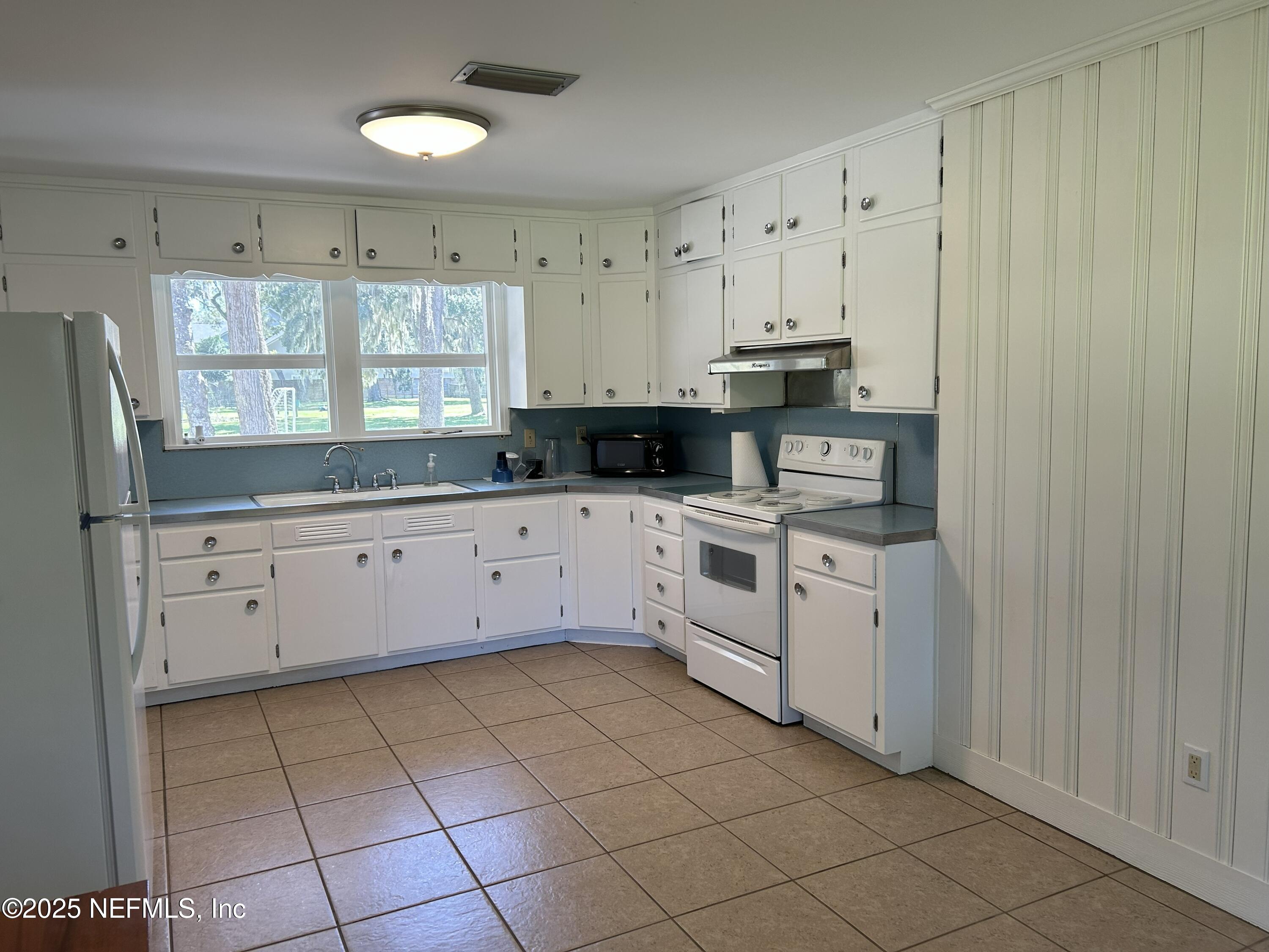 940 Myron Road Jacksonville, FL 32259 - Photo 6 of 20 a kitchen with granite countertop white cabinets white appliances and sink