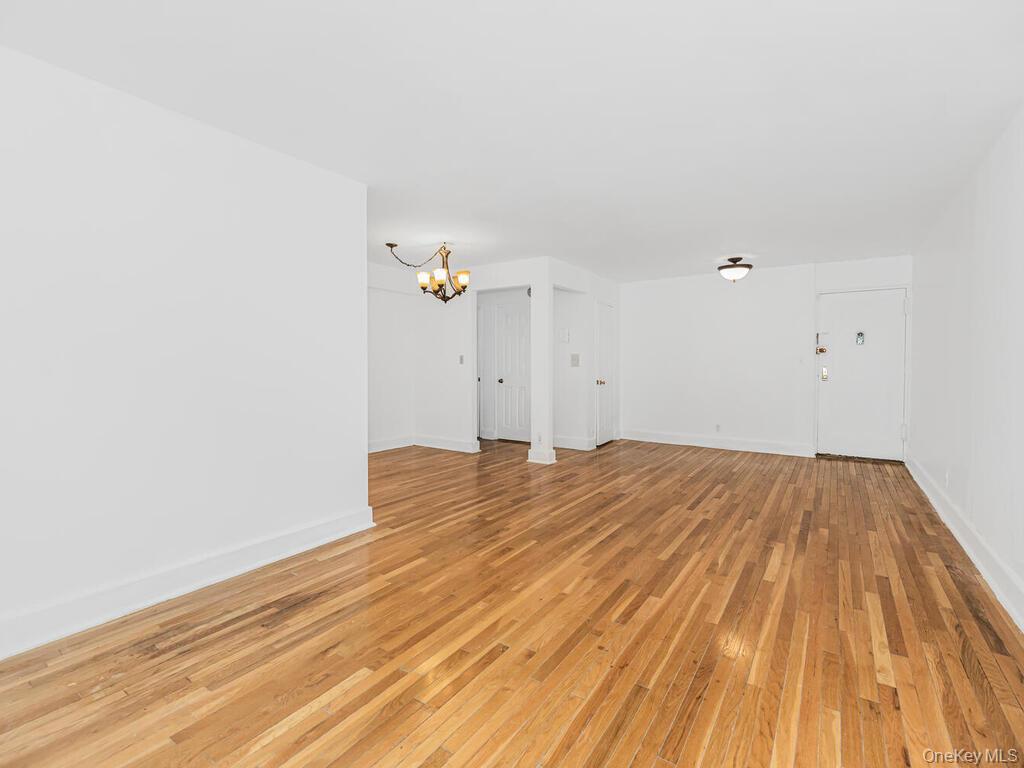 144 Ravine Avenue, Unit 2C Yonkers, NY 10701 - Photo 14 of 15 Unfurnished living room with an inviting chandelier and light wood-type flooring
