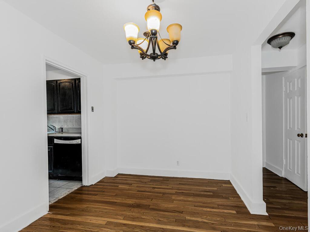 144 Ravine Avenue, Unit 2C Yonkers, NY 10701 - Photo 3 of 15 Unfurnished dining area with a chandelier and dark wood-type flooring