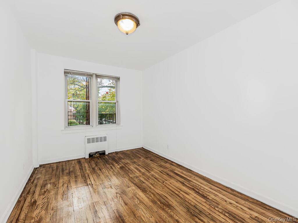 144 Ravine Avenue, Unit 2C Yonkers, NY 10701 - Photo 8 of 15 Spare room featuring hardwood / wood-style floors and radiator heating unit
