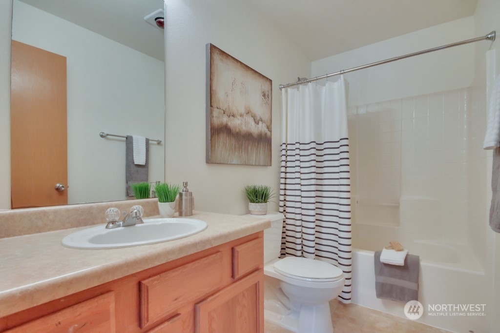 4010 East R Street Tacoma, WA 98404 - Photo 27 of 28 a bathroom with a granite countertop sink a toilet and a mirror