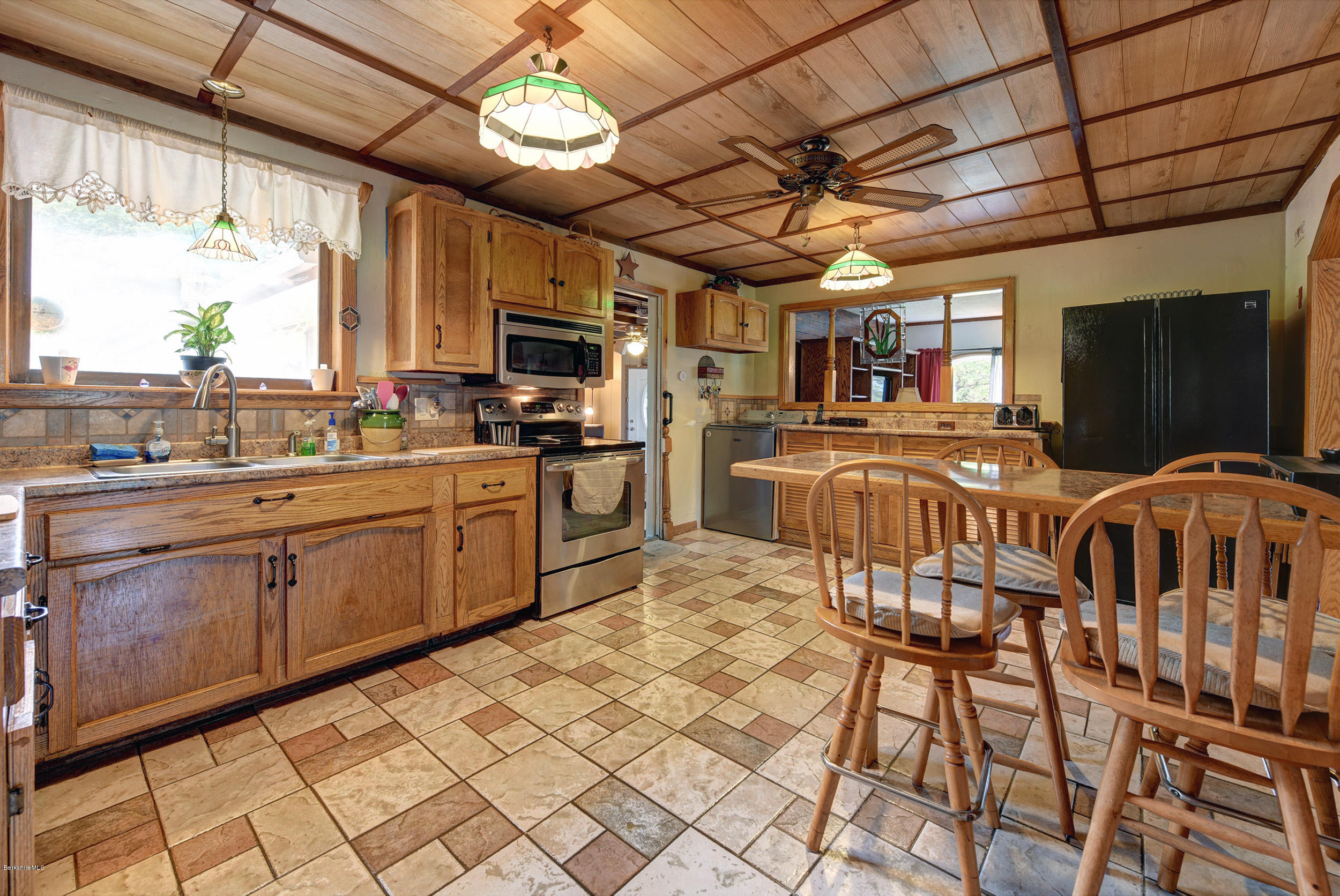 373 Haskins Road Savoy, MA 01256 - Photo 11 of 34 a kitchen with stainless steel appliances granite countertop a stove a sink dishwasher a dining table and chairs with wooden floor