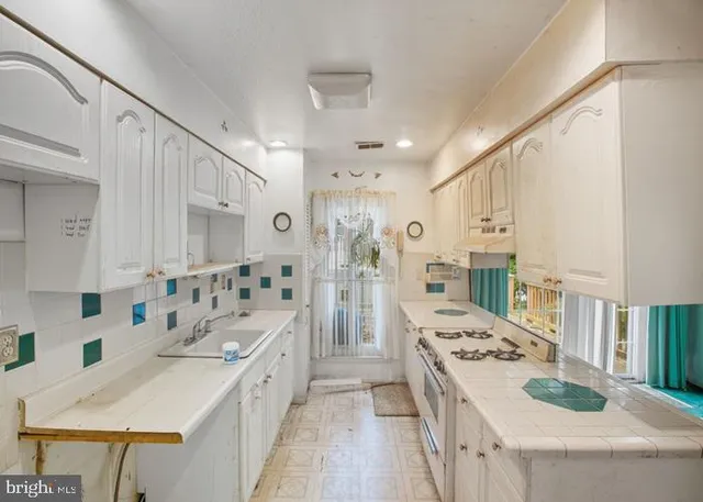 a kitchen with kitchen island a sink stove and refrigerator