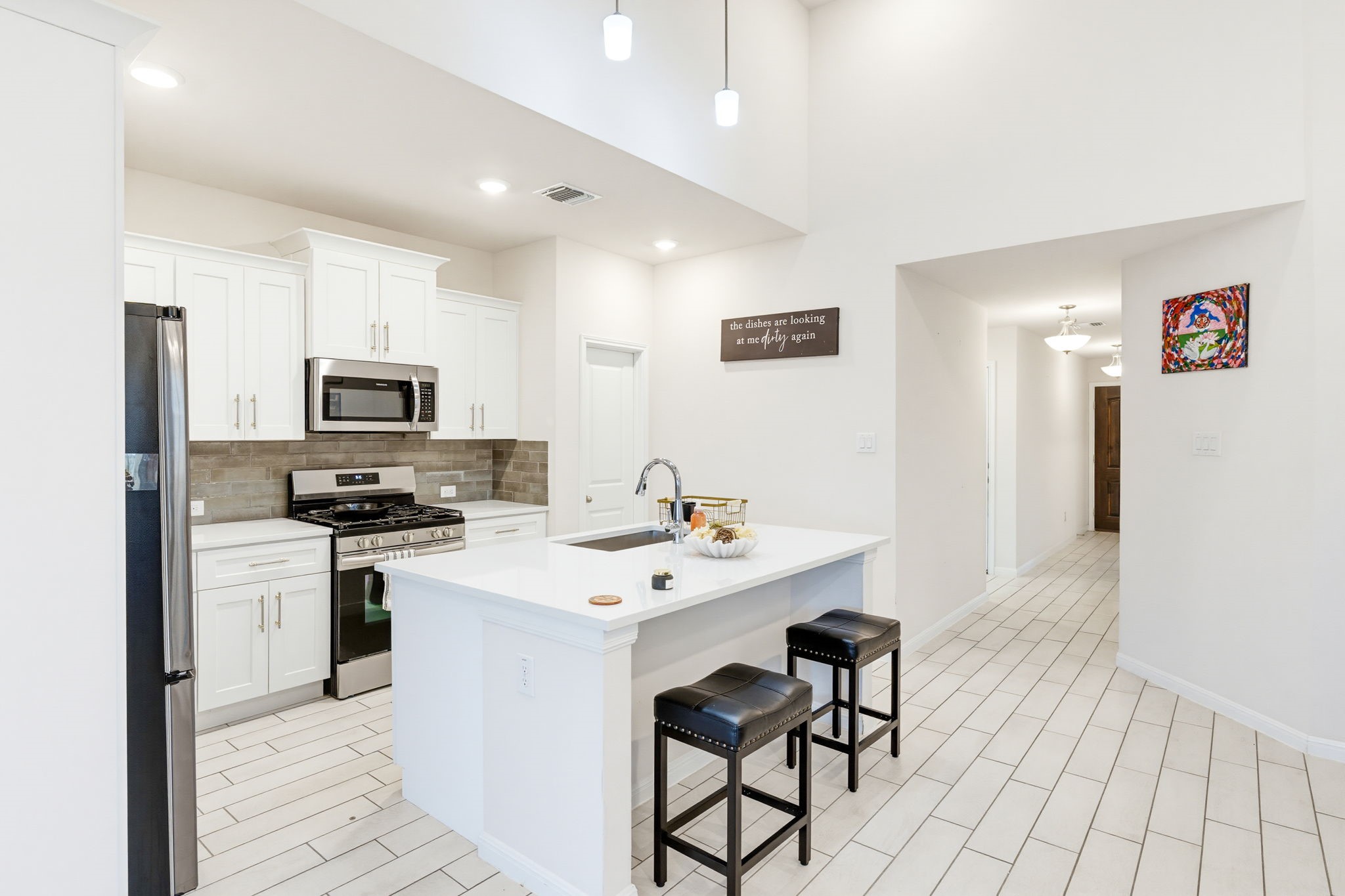 316 Windstar Road Liberty Hill, TX 78642 - Photo 7 of 27 a kitchen with stainless steel appliances a sink a stove a refrigerator with white cabinets and wooden floor