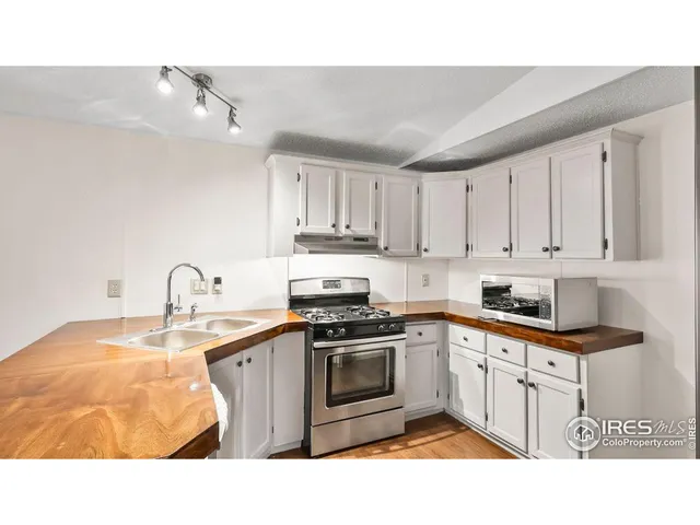a kitchen with granite countertop a sink stove and cabinets