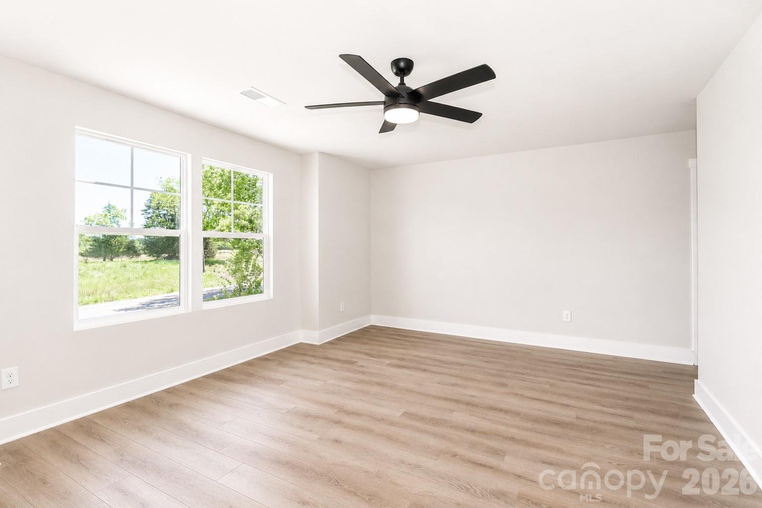 237 3rd Creek Road Stony Point, NC 28678 - Photo 10 of 29 an empty room with wooden floor fan and windows