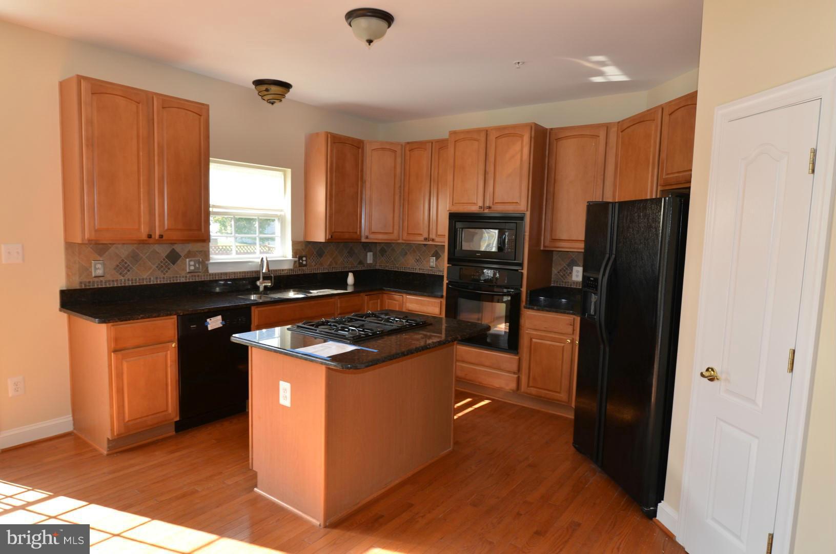 2105 Medinah Ridge Road Accokeek, MD 20607 - Photo 7 of 8 a kitchen with stainless steel appliances granite countertop a stove a refrigerator and a sink