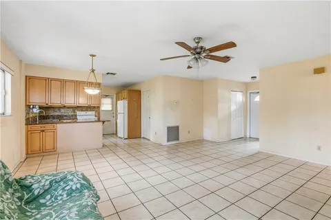 a view of kitchen with stainless steel appliances kitchen island granite countertop a refrigerator and a stove top oven