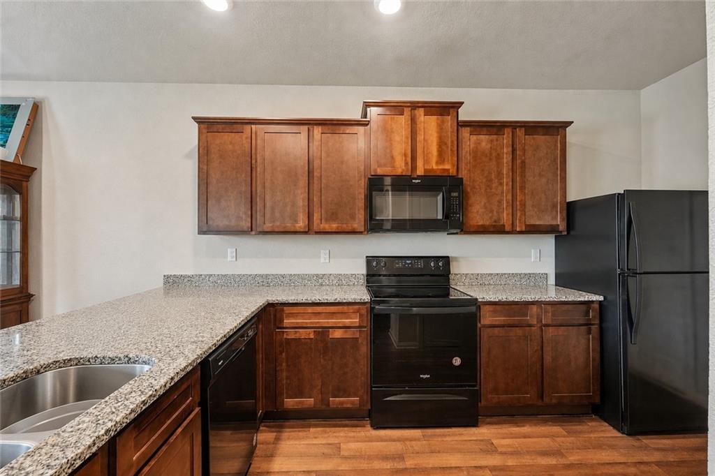 10933 Wheeler Trace Hampton, GA 30228 - Photo 7 of 22 a kitchen with stainless steel appliances granite countertop a sink stove and refrigerator
