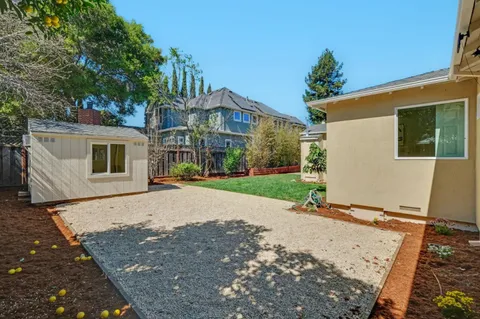 a view of a house with a yard and potted plants